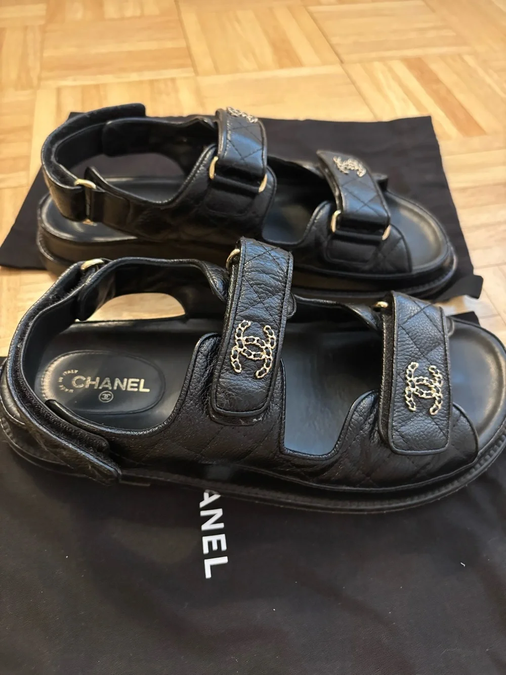 CHANEL Dad Black Leather Logo Strap Sandals with Gold CC Hardware.